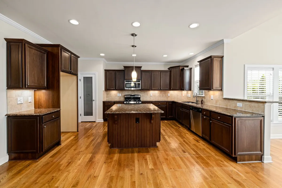 A residential kitchen ceiling with an even grid of six recessed can lights plus a pendant over the island